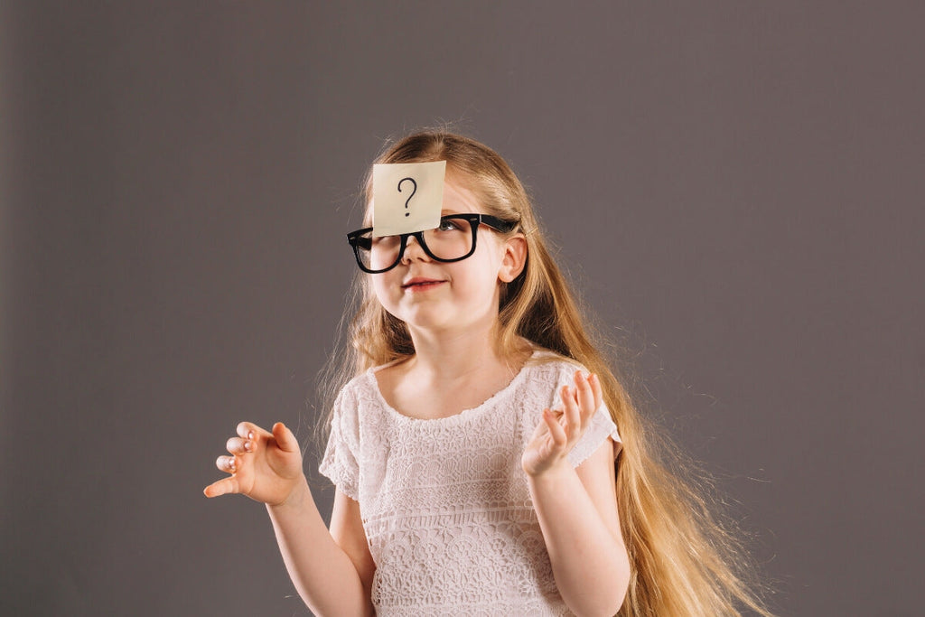 Little girl with a question mark note on her glasses. 