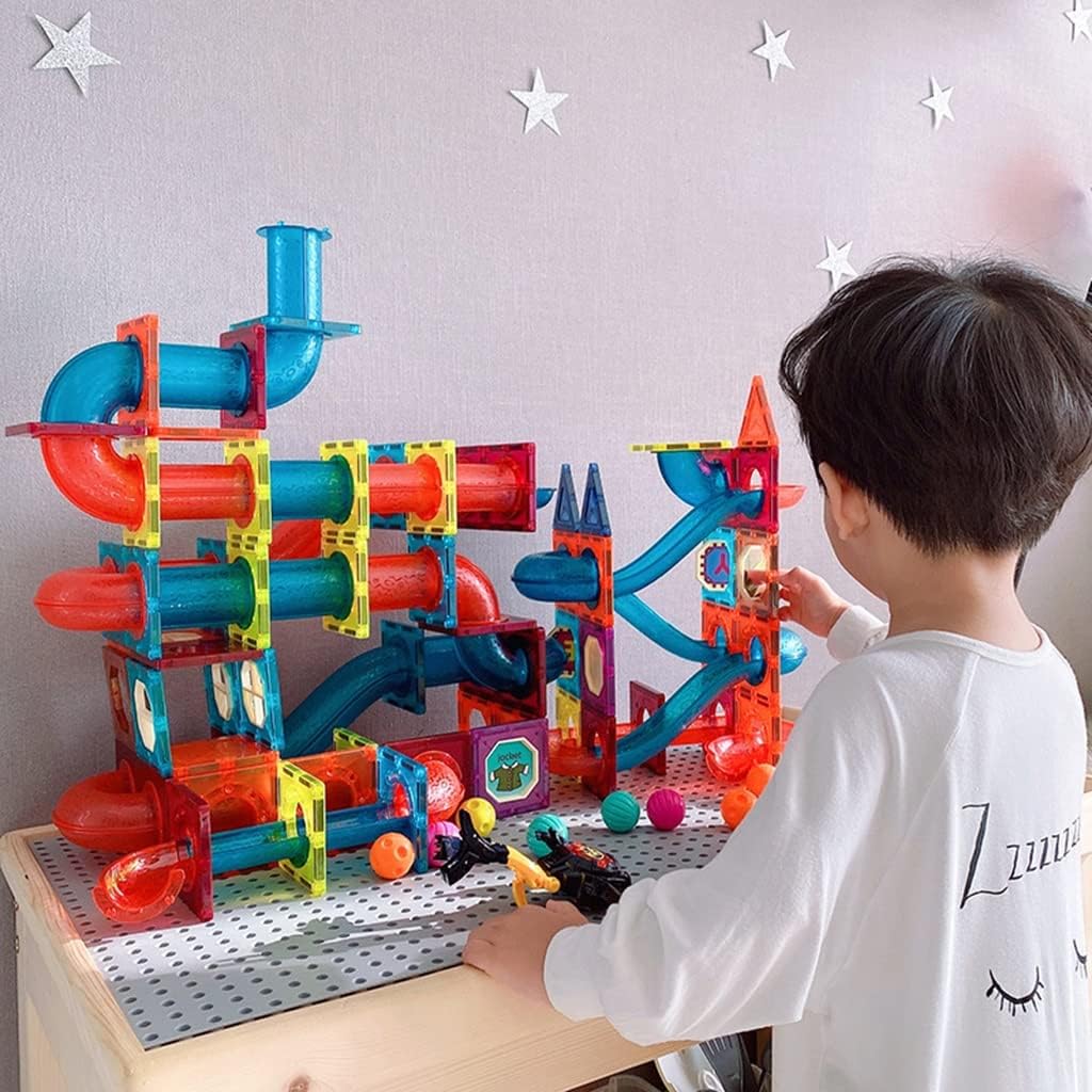 Little boy playing with a DIY Magnetic Marble Run set. 