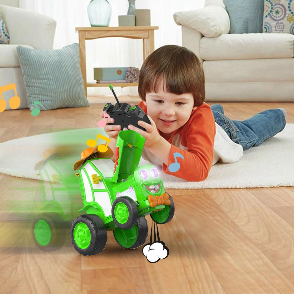 Little boy playing with a Tumble Tractor toy using a remote control.