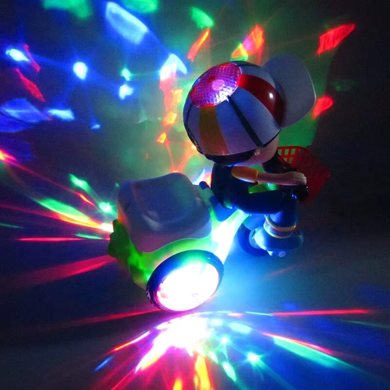 Twister Trike toy with multicolored LED lights illuminating a dark room. The toy features a child figure on a green tricycle with glowing wheels and a light-up cap, creating a vibrant, colorful display on the surrounding surfaces.