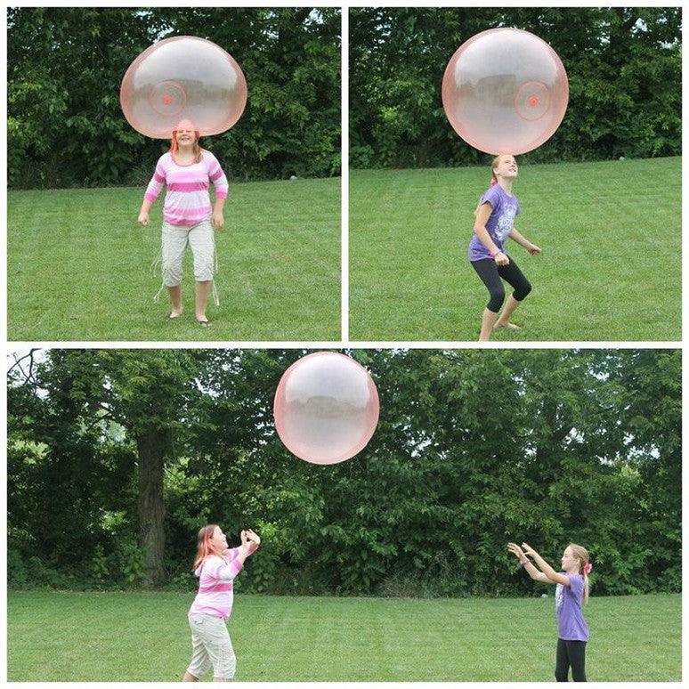 Children playing with a big and squishy wobble ball in the backyard.